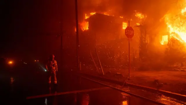 Firefighters battle flames from a raging wildfire on January 7, 2025 in the Pacific Palisades neighborhood of Los Angeles,