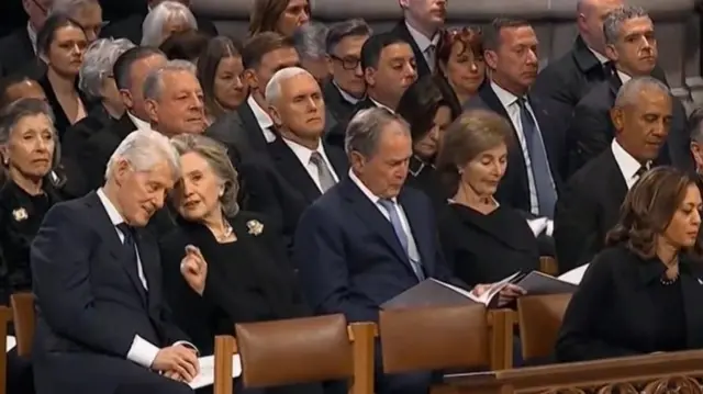 The Clintons seated next to the Bushs at the funeral