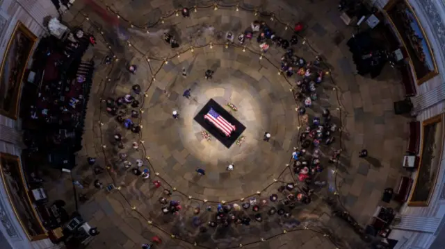 The body of President Jimmy Carter lay in place in the rotunda at the US Capitol, his casket draped in the American flag. Thousands dropped by to pay tribute to him in person, as seen in this overhead view