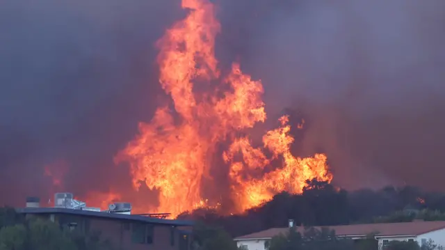 The Palisades Fire burns near homes amid a powerful windstorm on January 7, 2025