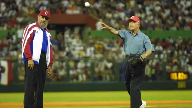 Castro watches as Carter throws a baseball in a packed stadium