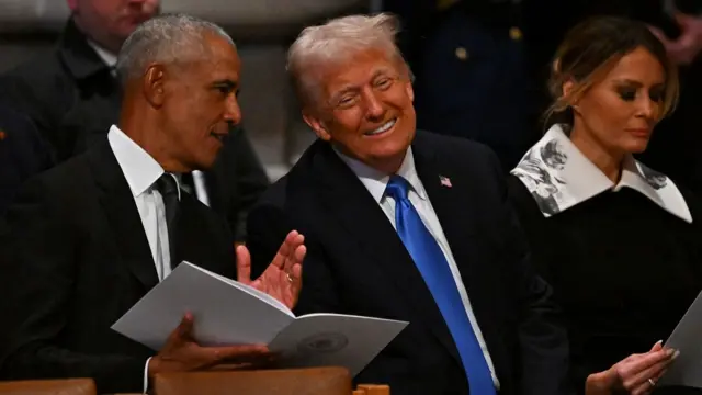 Trump smiles as he talks to Obama