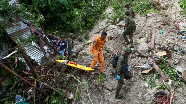 Rescuers and soldiers sift through debris in search of a person believed to be still trapped inside the house