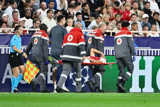 Vanderson (C) reacts as he is lifted off the pitch on a stretcher by medical staff