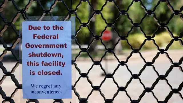 A sign on a fence informs people that a government facility is closed during the shutdown