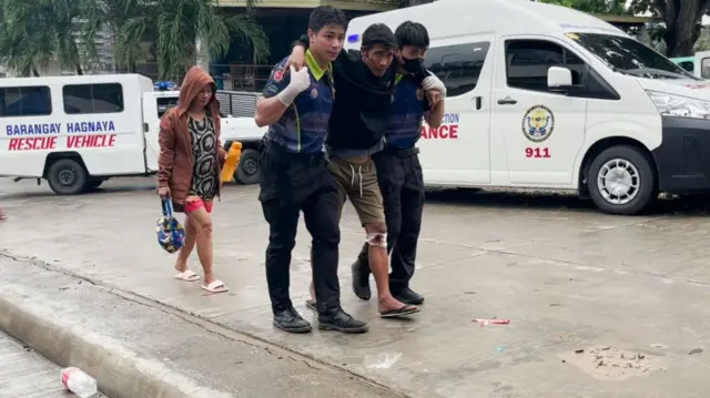 A injured man getting support from two paramedics
