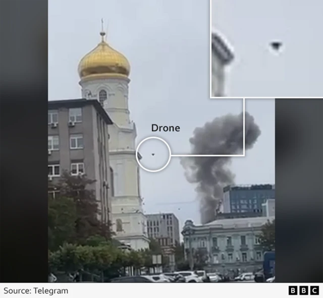 A screengrab taken from a verified video showing the drone attack in Dnipro - we've highlighted where you can see the drone in the image to the right of the gold-domed church