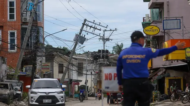 A policeman patrols a street in Cebu, Philippines that suffered heavy earthquake damage