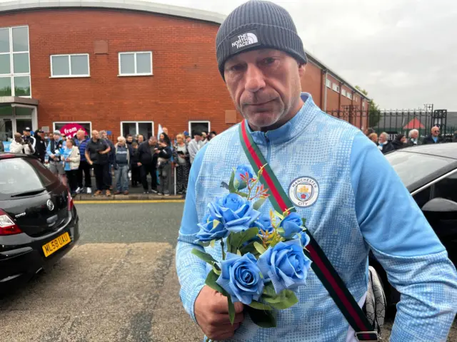 A mourner is standing outside Hatton's Gym