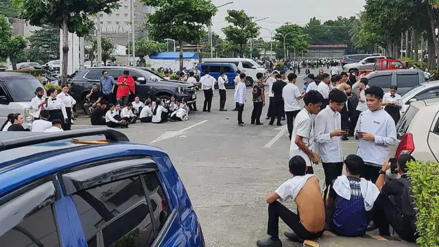 Employees at a shopping mall gather outside the building in Davao City