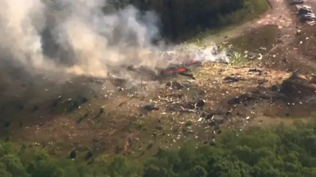 Charred pieces of metal scattered across the dirt