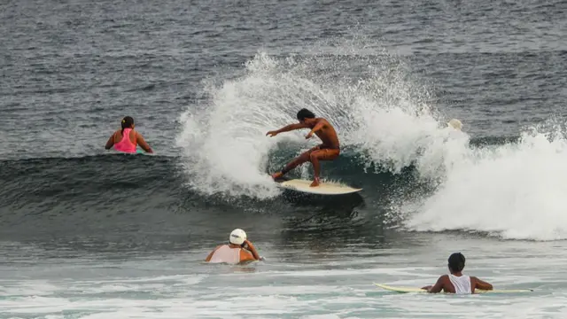 A tourist surfs the waves in General Luna town on the southern Philippine island resort of Siargao.