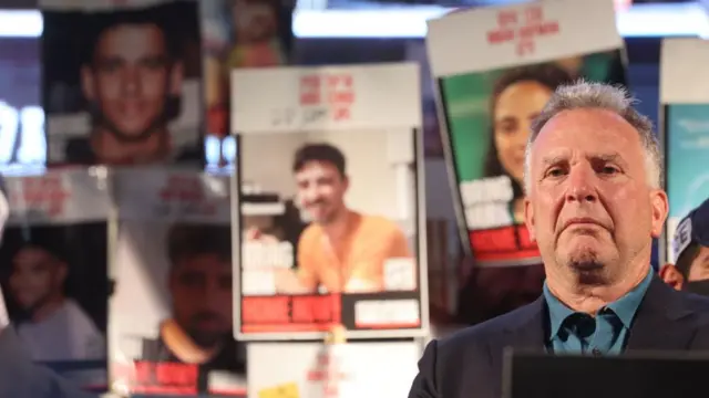 Witkoff stood at podium, signs and banners of hostages held by crowd behind him.