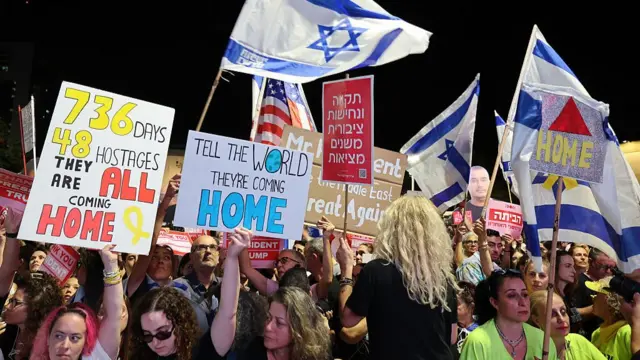 Large crowd in Tel Aviv's Hostages Square holds up placards with phrases in support of the ceasefire deal, including "Tell the world they're coming home"