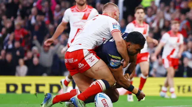Wigan's Bevan French fumbles the ball under pressure from Mikey Lewis