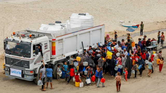 Displaced Palestinians fill containers with water amid a ceasefire between Israel and Hamas, in the central Gaza Strip, October 12, 2025.
