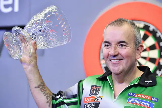 Phil Taylor holding the 2013 World Grand Prix trophy