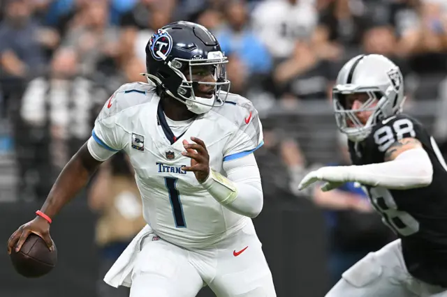 Cam Ward runs and is pursued by Maxx Crosby