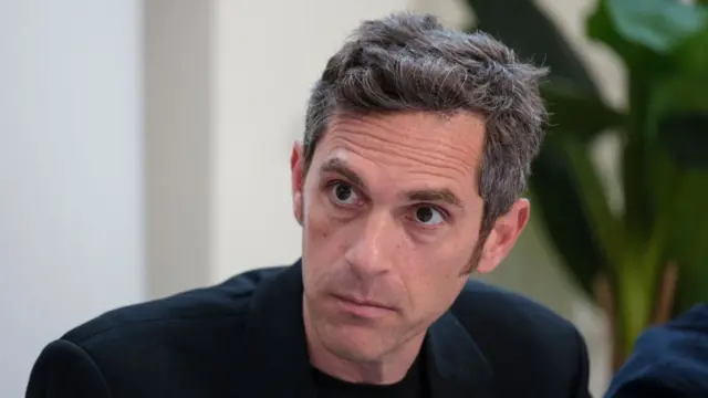 Headshot of Udi Goren, who has short greying hair and is wearing a dark jacket, speaking to media in January 2025.