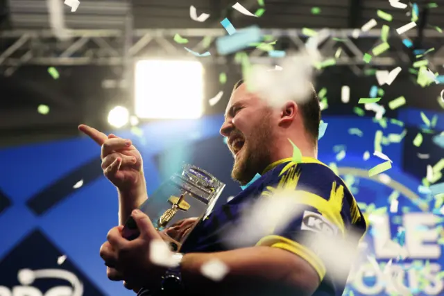 Luke Littler celebrates winning the World Grand Prix title