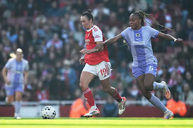 Caitlin Foord of Arsenal is challenged by Maelys Mpome of Brighton