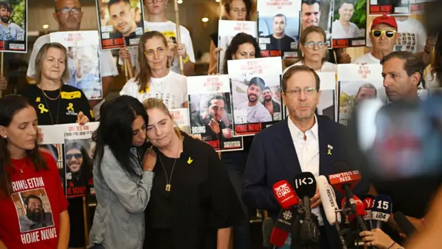 President of Israel, Isaac Herzog, flanked by his wife Michal Herzog (C), Einav Zangauker (2L), Ruby Chen (R) and the families of hostages .