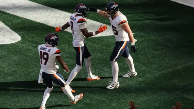 Nate Adkins celebrates a touchdown with Denver Broncos team-mates Marvin Mims and Troy Franklin
