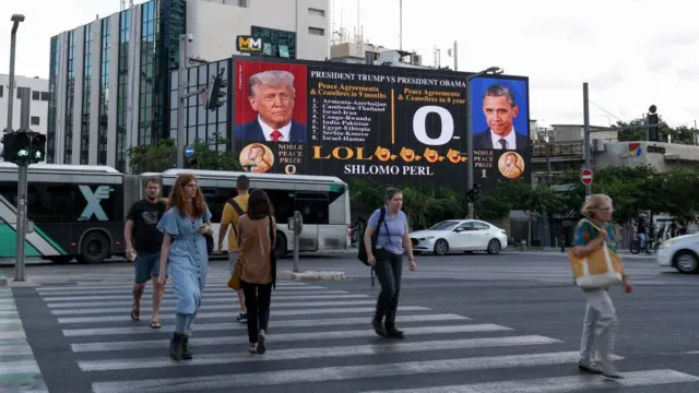 billboard shows images of U.S. President Donald Trump and former U.S. President Barack Obama, amid a ceasefire between Israel and