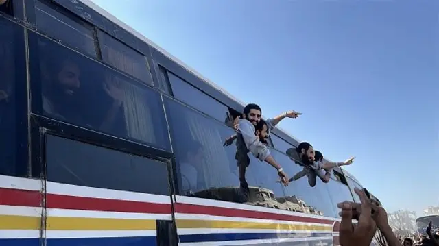 men smiling from a bus