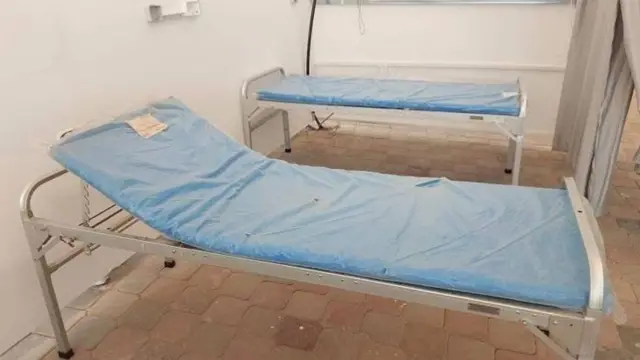 Two hospital beds with blue coverings