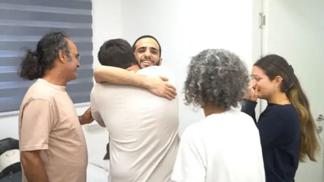 Nimrod Cohen (C) hugs his brother as his father, mother and sister observe