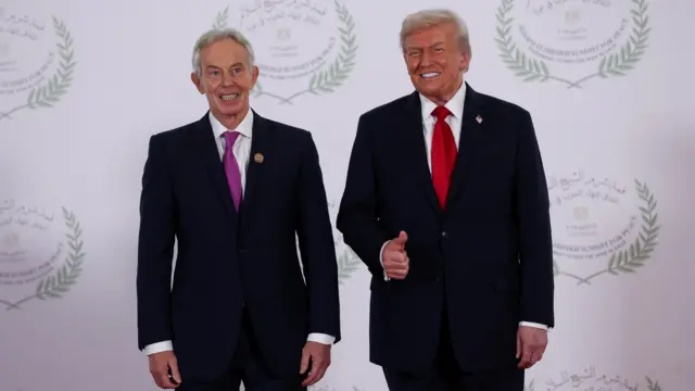 Tony Blair smiles next to Donald Trump