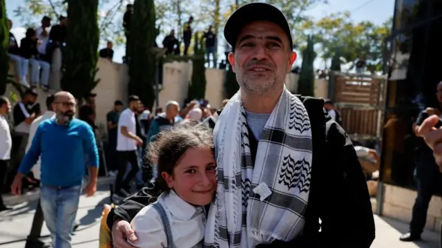 A man hugs a young girl