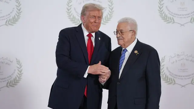 Donald Trump (L) shakes hands with Mahmoud Abbas (R) ahead of the signing