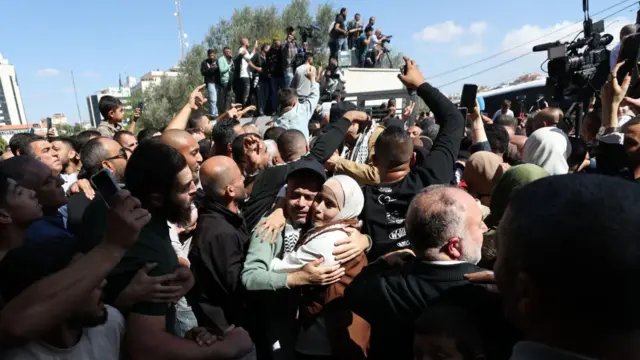 The scene in Ramallah, in the West Bank, earlier today as detainees were released. people embrace and crowds gather round a vehicle