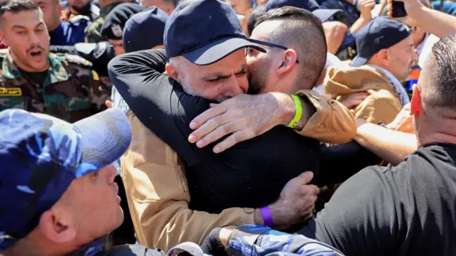 A freed Palestinian prisoner hugs his family member after being released from an Israeli jail as part of a hostages-prisoners swap and a ceasefire deal in Gaza between Hamas and Israel