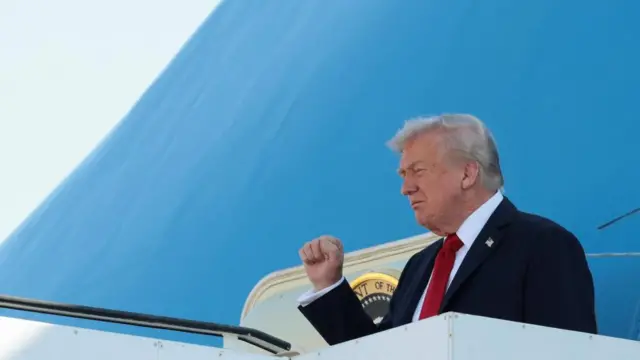 Trump fist pumps as he walks off plane