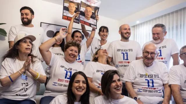 All wearing matching tshirts and smiling, looking excited