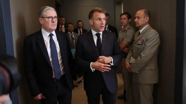Kier Starmer and Emmanuel Macron stand together in a hallway in Egypt
