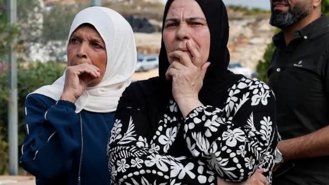 Families wait for their relatives on the day Palestinian prisoners are released from an Israeli jail