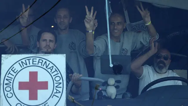 Palestinian men gesture from inside a bus after being released from the Ofer military prison located between Ramallah and Beitunia in the occupied West Bank