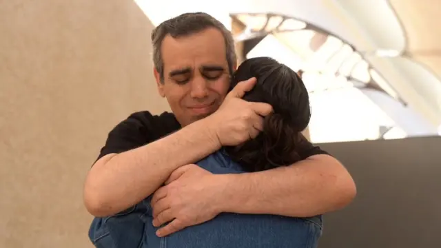 Omri hugging his wife