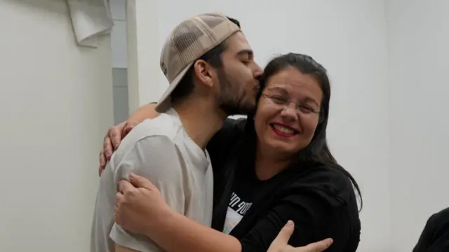 Hostage Yosef-Chaim Ohana (L) kisses his mother on the cheek (R)