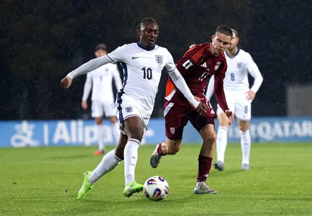 Eberechi Eze of England runs with the ball alongside Lukass Vapne
