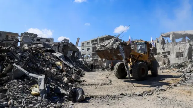 Heavy machinery removes debris from a destroyed street in Gaza