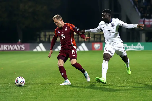 Andrejs Ciganiks of Latvia and Bukayo Saka of England battle for possession