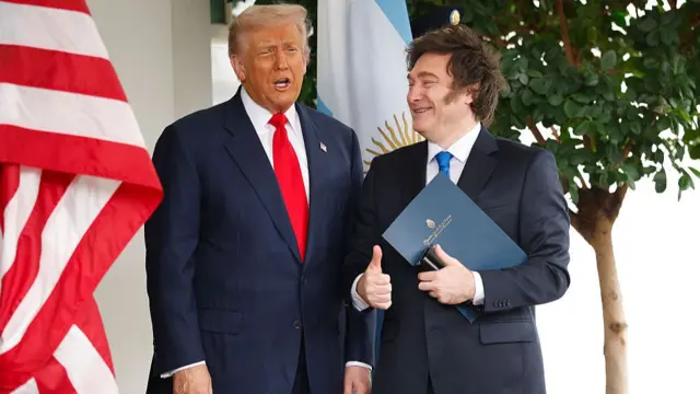 Trump speaks to press as Milei smiles and watches on