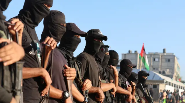 Palestinian militants clad in black stand in a line