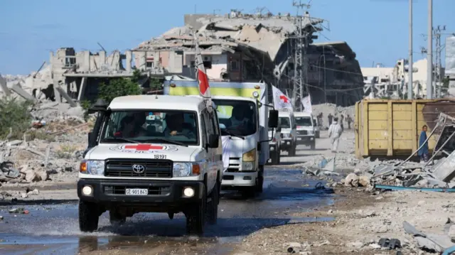 Red Cross vehicles escort a truck transporting the bodies of Palestinians who had been held in Israel during the wa