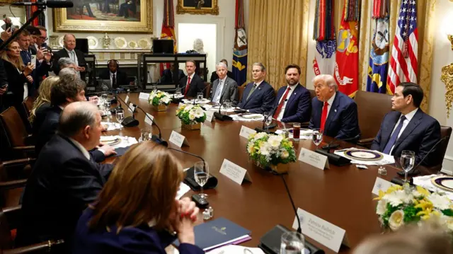 Trump and Milei at a long table in the White House, each flanked by several diplomats